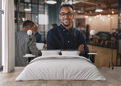 Smiling young businessman standing in a modern office Wall mural