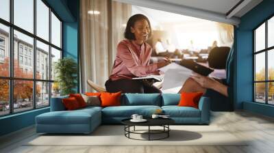 Smiling young businesswoman discussing paperwork with an office Wall mural