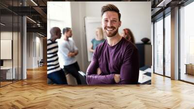 Smiling young designer standing in an office after a presentatio Wall mural