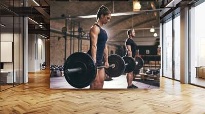 Sportive serious people lifting barbells in gym Wall mural