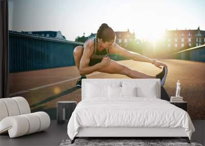 Sun highlights young muscular female athlete Wall mural