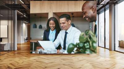 Three diverse businesspeople laughing while going over documents Wall mural