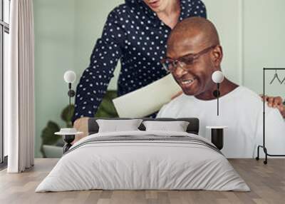 Two businessman working together on a laptop in an office Wall mural