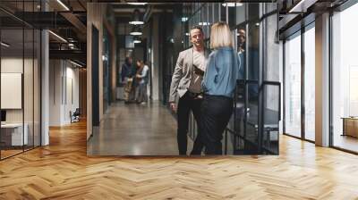 Two businesspeople talking together in an office hallway Wall mural