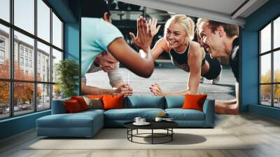 Two friends high fiving while planking on a gym floor Wall mural