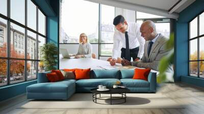 Two smiling businessmen discussing paperwork during a boardroom Wall mural