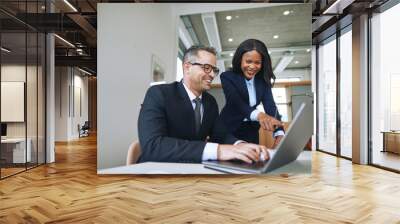 Two smiling businesspeople talking together and working with a l Wall mural