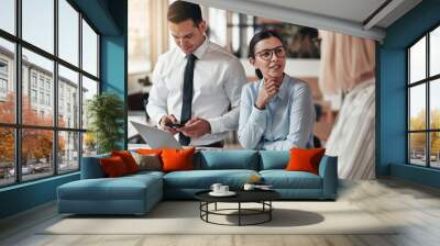 Two smiling businessswomen talking together at an office table Wall mural