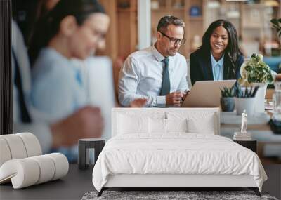 Two smiling diverse businesspeople using a laptop together at wo Wall mural