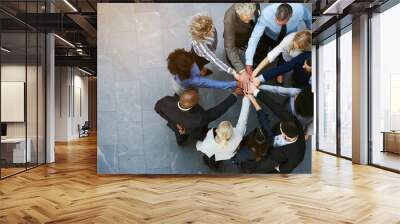 united businesspeople standing in a huddle with their hands together Wall mural