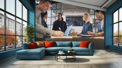 Young businessman talking with staff during an office meeting Wall mural