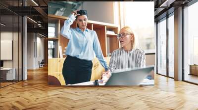 Young businesswoman and a colleague working at an office table Wall mural