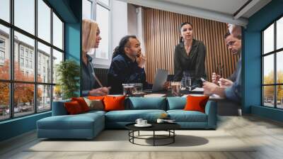 Young businesswoman talking with colleagues during a boardroom m Wall mural