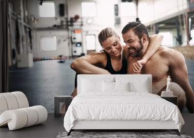 Young couple hugging on a gym floor after working out Wall mural