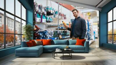 Young handyman shopping in a hardware store Wall mural