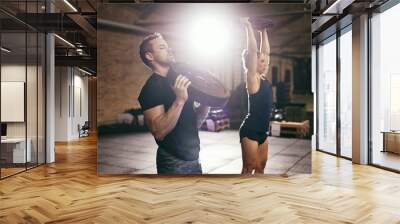 Young muscular sportive people training in gym Wall mural