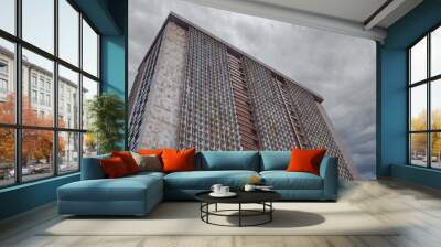 An artistic view of a textured building against a dramatic sky, showcasing modern architecture at its finest in Alicante, Spain Wall mural