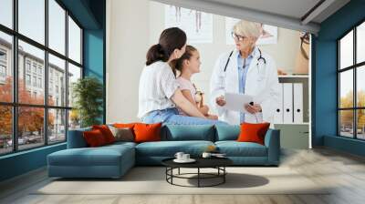 Doctor, child and talk in office for healthcare, medical advice or professional opinion with mom. Pediatrician, mother and daughter in consultation for kid recovery, diagnosis or medicare with report Wall mural