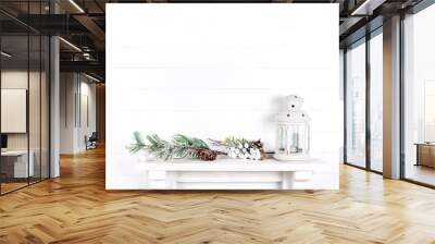 white wall in a room with a mantelpiece, spruce branches, cones and a lantern Wall mural