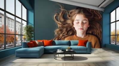 Fictional Caucasian young girl with long dark blonde hair relaxing on a dark olive green background - in banner size with copy space. Concept of beauty, relieving stress and anxiety. Wall mural