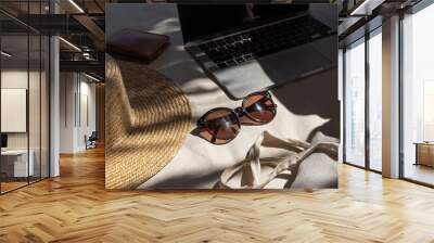 Aesthetic creative composition with women's fashion accessories. Stylish female sunglasses, straw hat, shopper bag, laptop on white lounge couch with pillows. Blurred sunlight shadows Wall mural