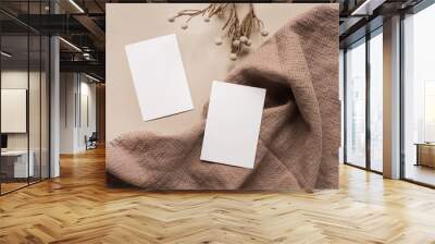 Blank paper sheet card with mockup copy space and dry floral branch and blanket cloth on neutral beige background. Minimal aesthetic business brand template. Flat lay, top view Wall mural