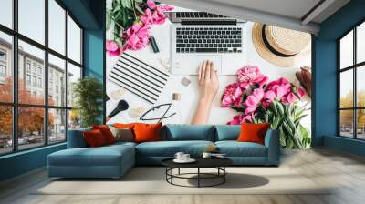 Flat lay styled office desk with laptop, pink peony flowers, cosmetics, accessories. Woman working on computer. Fashion or beauty blog background. Wall mural