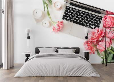 Laptop, pink peony tulip flowers, candles on white table. Flat lay, top view minimal workspace desk Wall mural