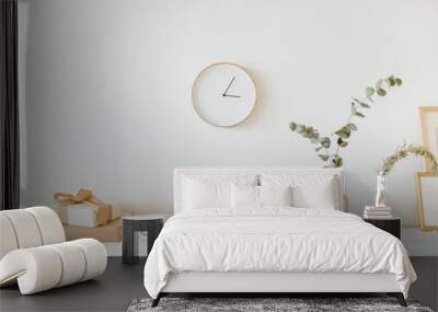 Modern interior design concept. Bright beige and golden apartment with clock, eucalyptus branch, vase, candle. Wall mural