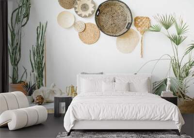 Modern minimal home interior design. Pillows, golden teapot, decorative straw plates, Scandinavian blanket, tropical palm tree, succulent and decorations. Wall mural