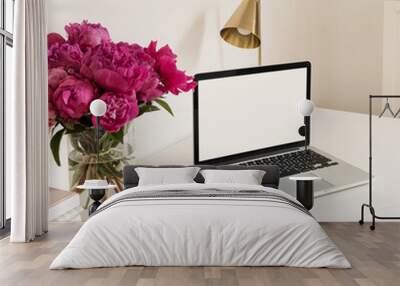 Office desk table workspace with blank copy space mock up laptop screen. Modern stylish home interior design with pink peonies flower bouquet. Front view blog, social media, website hero template. Wall mural