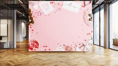 Valentine's Day, love concept. Mock up frame made of confetti, heart symbol accessories, sweets, postcards on pink background. Flat lay, top view. Wall mural