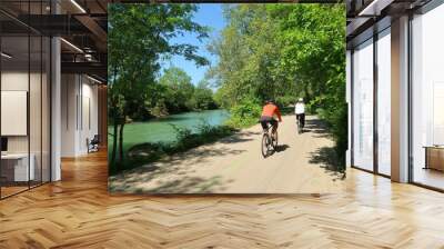 Cyclotourisme dans la campagne, au bord de la rivière Ouche à Dijon, en Côte d’Or / Bourgogne, paysage de nature avec deux cyclistes roulant sur une piste cyclable au bord de l'eau (France) Wall mural