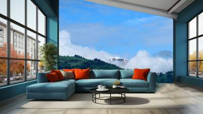 Clouds surround Mont Joly and Col de Voza and their forest in the Mont Blanc massif in Europe, France, the Alps, towards Chamonix, in summer, on a sunny day. Wall mural