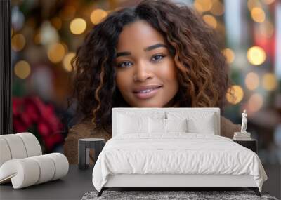 Portrait of a smiling black woman with curly hair, in a festive holiday setting with warm bokeh lights and decorations Wall mural