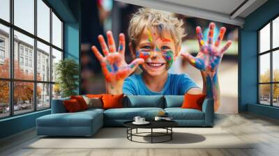 Smiling young boy with paint on his hands and face Wall mural