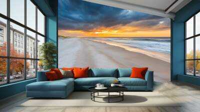 Stunning sunset over an empty beach with dramatic clouds Wall mural