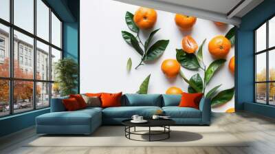 A close-up shot of juicy orange fruits and green leaves on a white background. Wall mural