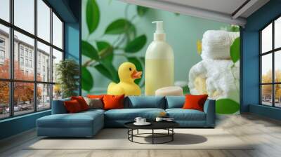 A yellow rubber duck, a bottle of lotion, a bar of soap, and two white towels on a table with green leaves. Wall mural