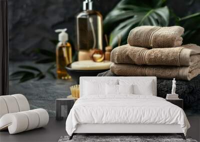 Spa essentials with towels, body brush, soap and oil bottles on a grey background. Wall mural