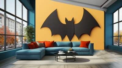 A black bat with a yellow background Wall mural