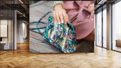 Ladies' handbag made of snake skin. Stylish women's accessories for summer: sunglasses, bracelet and handbag. The girl puts her glasses in her purse. Wall mural