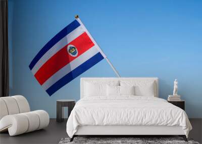 Woman hand with Costa Rica swaying flag on the blue sky. North America. Concept Wall mural