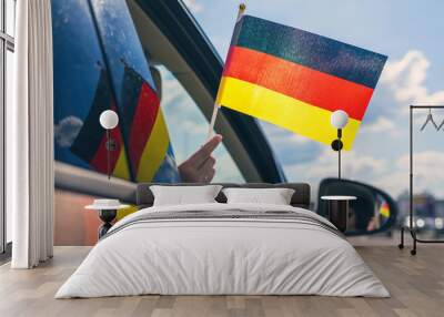 woman or girl holding germany flag from the open car window. concept Wall mural