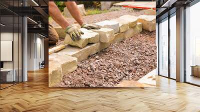 Man landscaping with natural stones -  Building of a dry stone wall Wall mural