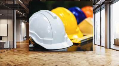 White and colored helmets that have different duties for the safety program of workers in the position of engineers or workers on the table. Wall mural