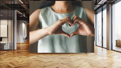 Close up of woman making heart shape for Valentines day, Mothers day and Breast Cancer Awareness month for Healthcare of International Women day Wall mural