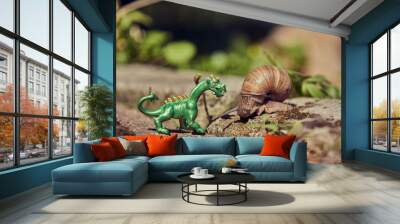 A grape snail and a small toy figure of a dragon. Wall mural