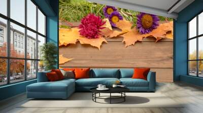 Frame of autumn bright leaves, apples, berries and flowers on a wooden background.Flat Lay, Top View Wall mural