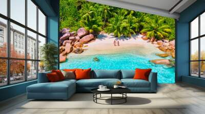 Anse Lazio Praslin Seychelles, a young couple of men and women on a tropical beach during a luxury vacation in Seychelles. Tropical beach Anse Lazio Praslin Seychelles Wall mural